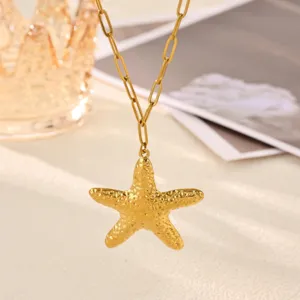 Gold starfish pendant necklace detail shot, textured sea star charm on paperclip chain.