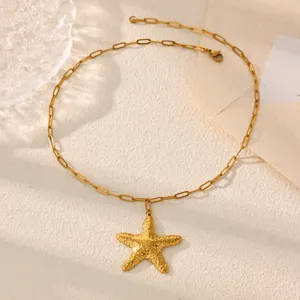 Gold starfish pendant necklace detail shot, textured starfish charm on paperclip chain.