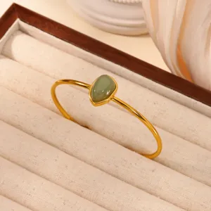 Minimalist stainless steel 18k gold plated open cuff bracelet with green stone detail.