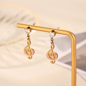 Exquisite gold-plated treble clef earrings with sparkly heart crystal and chic pink enamel.