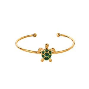 Gold plated stainless steel open cuff bracelet with green glitter turtle pendant for women.