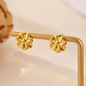 Gold flower stud earrings detail close up view, polished metal jewelry accessory design.