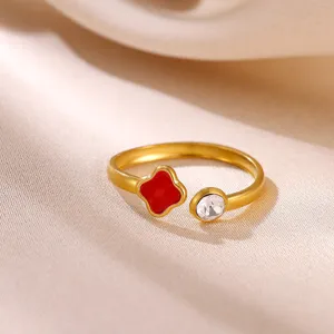 Close-up detail of the 18k gold plated open ring with red clover and crystal stone.
