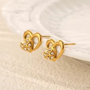 Detailed shot of trendy gold double heart rhinestone stud earrings, elegant jewelry design.