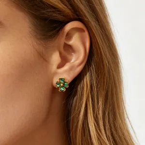 Close-up shot of green zircon four-leaf clover stud earrings, highlighting delicate jewelry details.
