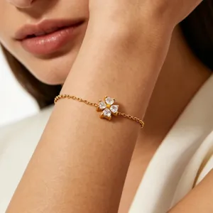 Detail shot of gold-plated clover pendant bracelet with sparkling zirconia stones for women.