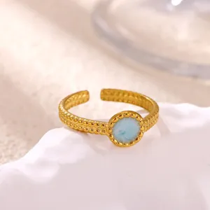 Close-up detail shot of the gold-plated stainless steel open ring featuring a blue resin inlay.