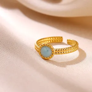 Close-up detail of the elegant 18k gold plated open ring with textured double band and blue stone.