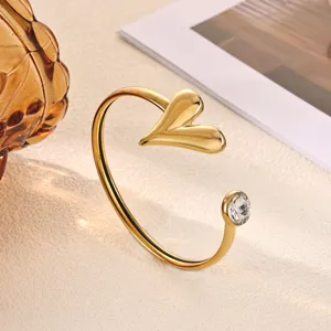 Gold plated open cuff bracelet featuring a puffy heart and sparkling crystal detail for women.