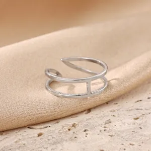 Close-up of minimalist stainless steel open ring, sleek multi-layer geometric band.