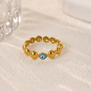 Close-up of gold-plated stainless steel evil eye ring, showcasing detailed bead and blue enamel.