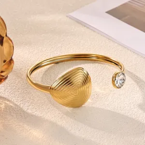 Detailed shot of gold-plated open bracelet with sparkling diamond accent and unique texture.