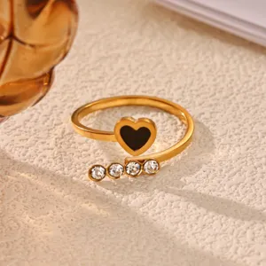 Close-up detail of 18k gold plated stainless steel open ring with black heart and sparkling crystals.