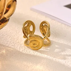 Close-up detail of gold plated stainless steel spiral ammonite open ring, elegant design texture.