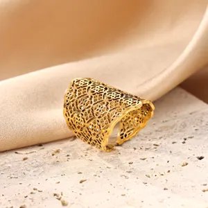Detailed shot of a wide openwork gold plated ring with intricate lace web design.
