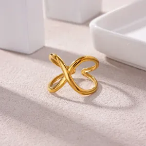 Close-up of gold plated stainless steel open ring with modern geometric cross design for women.