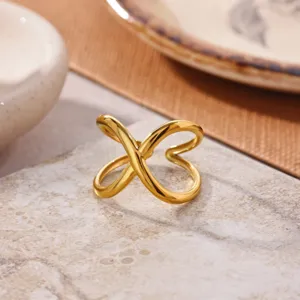 Close-up detail view of the elegant minimalist stainless steel gold plated open crossover ring.