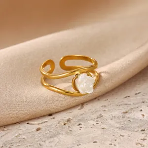 Close-up detail of gold-plated stainless steel ring featuring a white rose floral accent.