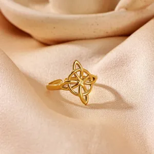 Detailed shot of gold-plated stainless steel open ring with intricate geometric knot design.