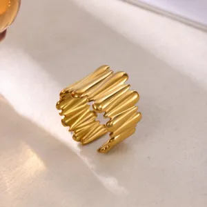 Detailed closeup of a wide molten style gold plated stainless steel open ring, aesthetic jewelry.
