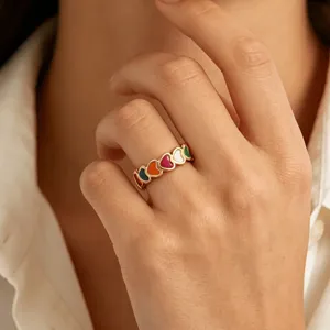 Close-up of a stylish gold plated stainless steel ring featuring colorful enamel hearts.