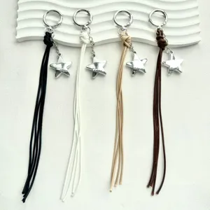 Minimalist braided leather cord star keychain and bag charm detail, metal star pendant.