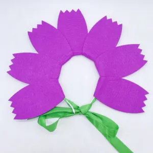 Details of the felt flower hair accessory, showing purple petals and green ribbon ties.