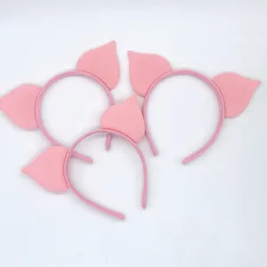 Close-up detail of cute pink pig ear headbands, soft fabric costume hair accessories set.