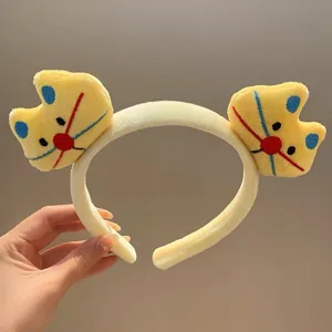 Detalle de diadema de felpa estilo dibujos animados, material amarillo suave y bonito.