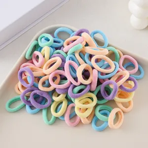 Detailed close-up of colorful seamless hair ties in a white tray, soft pastel elastics.