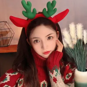 Serre-tête de renne de Noël mignon avec des oreilles rouges et des bois verts moelleux.