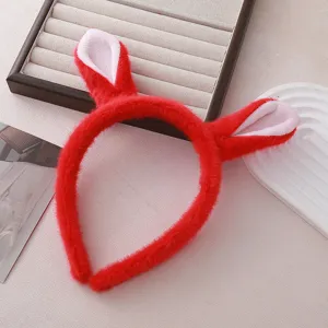 Détail serre-tête oreilles animal peluche rouge, texture douce, accessoire de fête mignon.