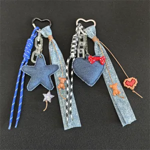 Detailed view of denim heart star keychain, fabric ribbon charm, trendy bag accessory.