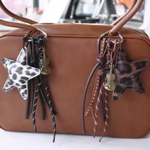 Charmant pendentif sac étoile léopard avec violon en métal et franges cuir pour porte-clés.