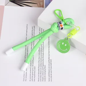 Close-up detail of neon green woven lanyard with cute smiley pendant and clip for phone case.
