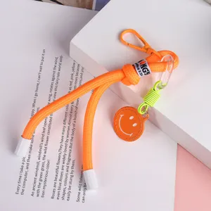 Orange braided phone lanyard keychain with cute smiley face charm for bags and keys.