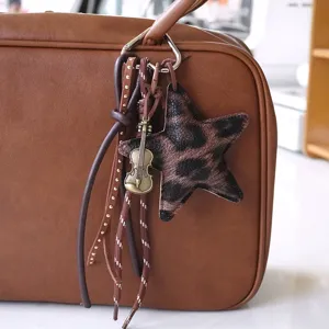 Breloque de sac étoile imprimé léopard avec pendentif violon rétro et glands en cuir pour sacs.