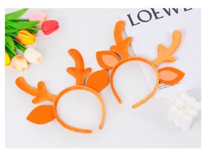 Primo piano dettaglio di cerchietto peluche corna di renna, arancione, perfetto per festa Natale.