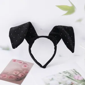 Close-up of black velvet bunny ear hair hoop, cute party headband accessory detail.