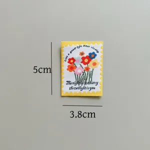 Close-up of cute floral stamp woven fabric patch for DIY handmade sewing clothing accessories.