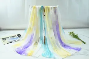 Gradient chiffon scarf detail shot, elegant tie-dye colors of yellow, blue and purple.