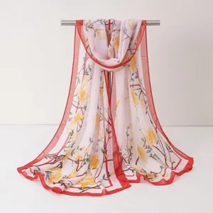 Vue détaillée d'écharpe en mousseline légère avec imprimé floral et bordure rouge.