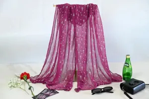 Detail view of the purple pleated chiffon scarf featuring shimmering gold sequins and elegant drape.