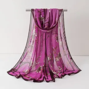 Vue détaillée d'un élégant foulard en mousseline à motif floral violet drapé sur support.