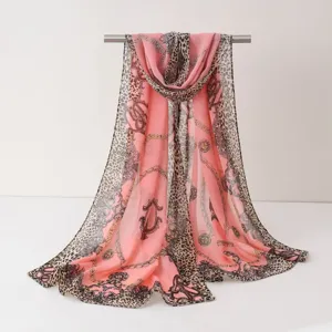 Écharpe en mousseline rose pour femme avec imprimé léopard et chaîne baroque chic.
