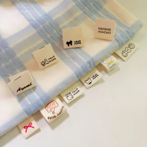 Close-up detail of cotton folded labels with cute cartoon animal prints for DIY crafts.