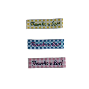 Checkered woven labels with embroidered thanks a lot text for clothing accessories.