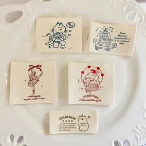 Detailed view of cute cotton woven labels with various cartoon illustrations and English text.