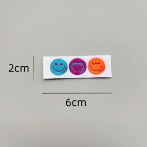Detailed closeup of colorful embroidered smiley face fabric label for DIY clothing decoration.