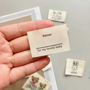 Close-up of handmade cotton fabric label with custom name text, perfect for DIY baby clothing.